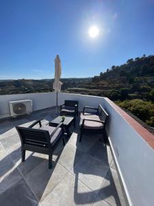 patio z 3 krzesłami i stołem na dachu w obiekcie Apartamento en Frigiliana w mieście Frigiliana