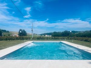 a swimming pool in a yard with a blue sky at Pietralunga Resort in Fidenza