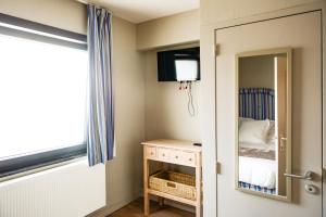 a bedroom with a mirror and a bed at La marelle in Blaregnies