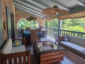 a living room with a table and chairs on a porch at Demeure de charme OLIVIRA in Vesseaux