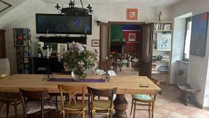 a dining room table with a vase of flowers on it at Apartamento Pino Verde in San Colombano VT Vista, Natura, Wifi in San Colombano