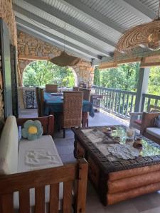 a living room with a table and chairs on a porch at Demeure de charme OLIVIRA in Vesseaux