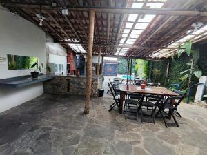 a patio with a table and chairs and a bar at Pousada Acayaca in Diamantina