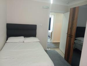 a bedroom with a white bed with a black headboard at Sama house in Rize