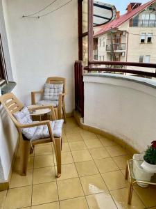 a balcony with chairs and a table and a window at City Square Apartment 1st floor in Strumica