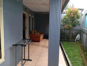 a porch with a bench and a couch in a house at Villa STS Cisarua Puncak in Cisarua
