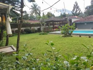 a yard with a pool and a house at Villa STS Cisarua Puncak in Cisarua +5 photos