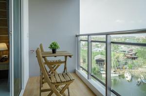 a wooden chair sitting next to a table on a balcony at NEW amazing studio a private marina in Na Jomtien