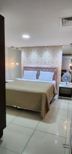 een slaapkamer met een groot bed en een spiegel bij Flat Marinas 002 in João Pessoa