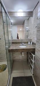 een badkamer met een wastafel en een spiegel bij Flat Marinas 002 in João Pessoa
