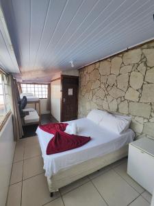 a bed in a room with a stone wall at Pousada Acayaca in Diamantina +230 photos