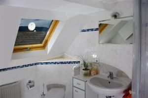 La salle de bains est pourvue d'un lavabo, de toilettes et d'une fenêtre. dans l'établissement Gasthaus Korfu, à Edenkoben