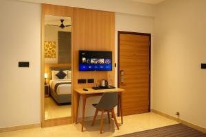 a room with a bedroom with a bed and a desk at Dlite Rivera Luxury Service Apartments in Bengaluru