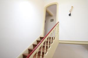 una escalera en una casa con paredes blancas y escaleras de madera en Casa 11 Cravos by LovelyStay, en Figueira da Foz