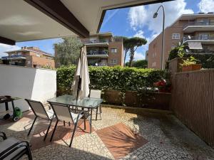 a patio with an umbrella and a table and chairs at camera con bagno privato in Rome