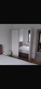 a bedroom with a large white bed and a mirror at J&M Apartman Zlatibor in Zlatibor +10 photos