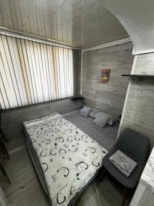 una pequeña habitación con una cama y una silla en HotelJosefine, en Chişinău