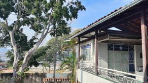 a house with a porch and a tree at HOTEL ESTAÇÃO in Diamantina