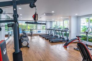 a gym with a row of treadmills and ellipticals at Beautiful studio by the beach with private marina in Na Jomtien