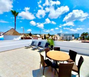 a patio with a table and chairs on a roof at Chrystal Rocks Apartment in Ayia Napa