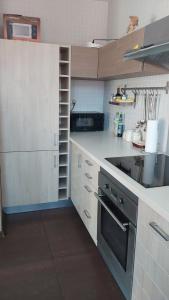 a kitchen with white cabinets and a black stove at Apartament Słoneczna Skarpa in Rabka