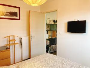 a bedroom with a refrigerator and a tv on the wall at KER NALA - Jolie maison familiale pour 5 vacanciers in Plouharnel