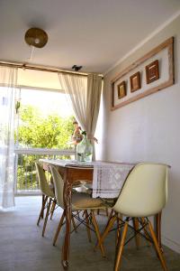 a dining room with a table and chairs and a window at CasaNativa Sur Depto Diseño Boho in Curicó