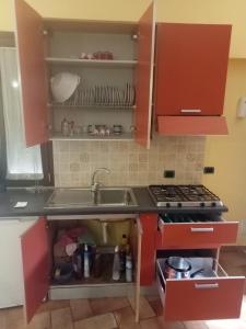 a kitchen with red cabinets and a sink at Casa del dottore in Cefalù +28 photos
