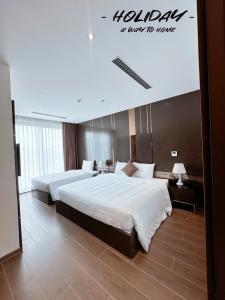 a hotel room with two beds and a sign on the wall at Holiday Hotel Van Don in Tài Xá +11 photos