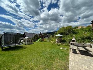 ein Hof mit Spielplatz und Schaukel in der Unterkunft Apartmány Aram Kubínska hoľa in Dolný Kubín