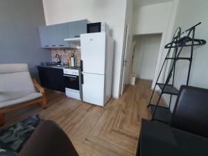 une cuisine avec un réfrigérateur blanc dans une pièce dans l'établissement Metropolitan Apartment next to Presidential Palace, à Bratislava 30 autres photos