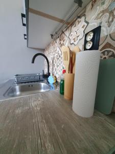 un comptoir de cuisine avec un évier et un bloc de couteau dans l'établissement Metropolitan Apartment next to Presidential Palace, à Bratislava