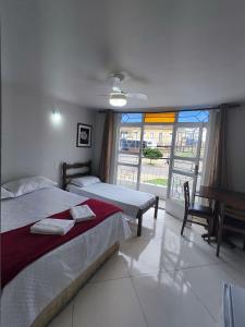 a bedroom with two beds and a large window at HOTEL ESTAÇÃO in Diamantina