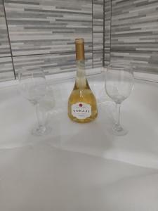 a bottle of wine sitting between two wine glasses at MilicaNS2 in Novi Sad