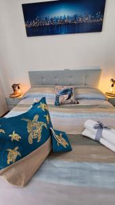 a bed with a blue comforter and towels on it at Appartamento Tortuga in Lignano Sabbiadoro