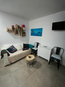 een woonkamer met een bank en twee stoelen bij La Casa d'Audenge in Audenge