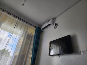 a living room with a tv and a window at Cozy 1 bedroom Coastal Condo Beachside Bliss Near Golf & Adventure in Malindi