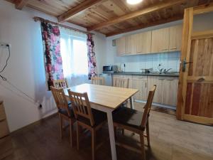 a kitchen with a wooden table and chairs at Przy wodzie - Jacnia in Jacnia