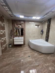 a bathroom with a large tub and a sink at La villa de Ramil in Baku