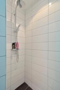 a shower in a bathroom with white tiles at Hotel La Belle Vue in Amsterdam