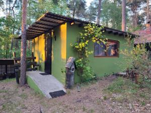 a small green and yellow house in the woods at Pirat Turawa in Turawa