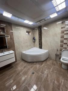 a large bathroom with a tub and a toilet at La villa de Ramil in Baku +12 photos