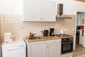 a kitchen with white cabinets and a sink at CosyHomes24 - Centrally with balcony and parking space - Ge09b in Gelsenkirchen +23 photos