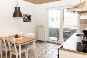 a kitchen and dining room with a table and chairs at CosyHomes24 - Centrally with balcony and parking space - Ge09b in Gelsenkirchen