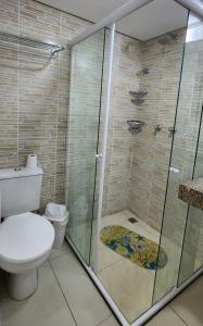 een badkamer met toilet en glazen douche bij Flat Marinas 002 in João Pessoa +11 foto's