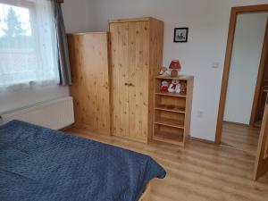 a bedroom with a bed and a wooden cabinet at Rekreační dům in Dobříš