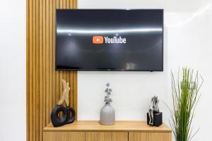 a television on a wall above a wooden shelf at Miramar Residence Beach in Mohammedia