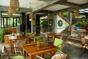 a restaurant with wooden tables and chairs at Gaia Soul in Godauda