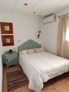 ein weißes Schlafzimmer mit einem Bett und einem Fenster in der Unterkunft Casa Rural El Patio in Valmuel