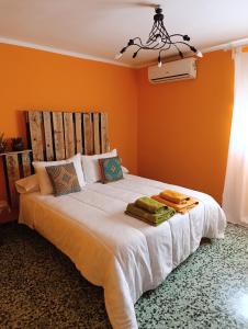 ein Schlafzimmer mit einem großen weißen Bett mit orangefarbenen Wänden in der Unterkunft Casa Rural El Patio in Valmuel